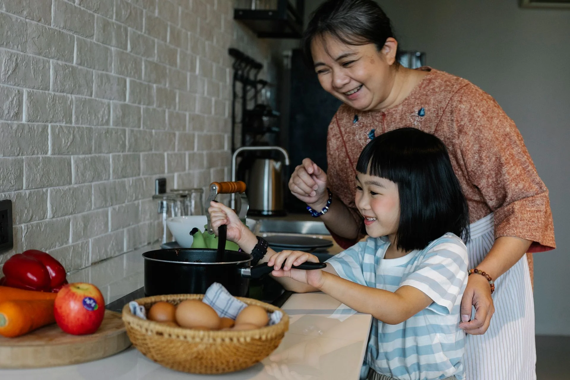 A grandmother and granddaughter preparing a meal together at home