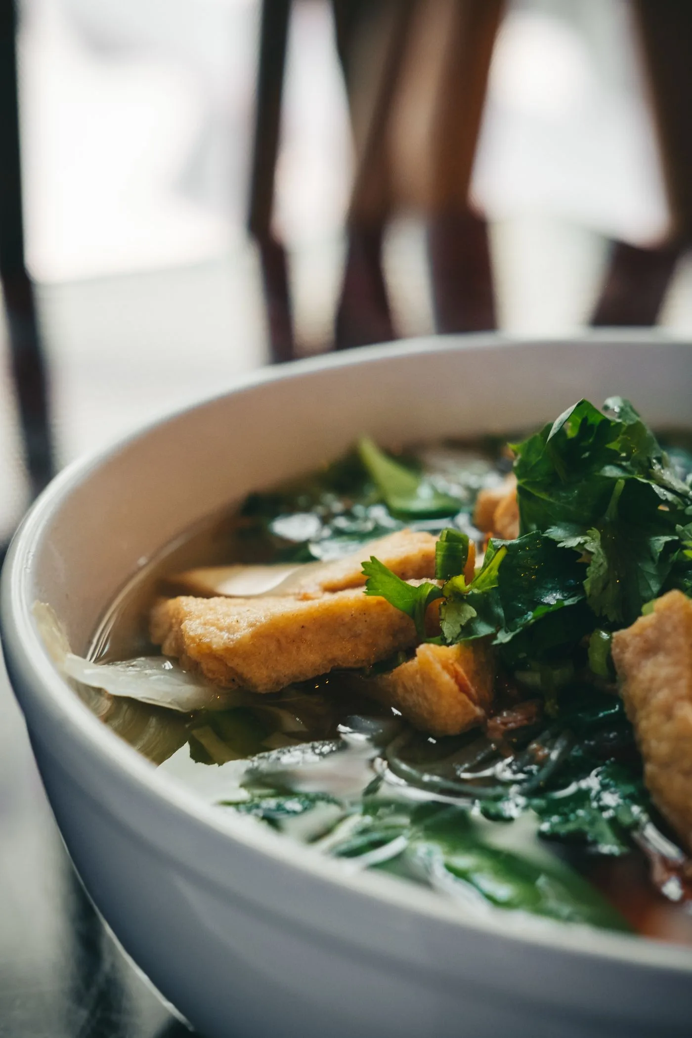 A bowl of Vietnamese pho with fresh herbs and familiar ingredients